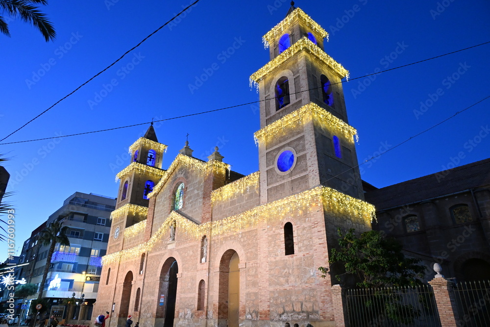 Obraz premium kościół wieżyczka dzwonnica oświetlony lampki cegła niebieskie niebo palmy