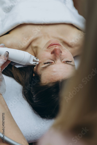 Professional cosmetologist performing LPG facial skin massage for rejuvenation in beauty salon.