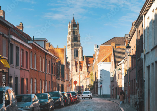 Bruges, Belgium- September 24, 2023. St. Salvator Cathedral tower and cozy narrow street with old buildings