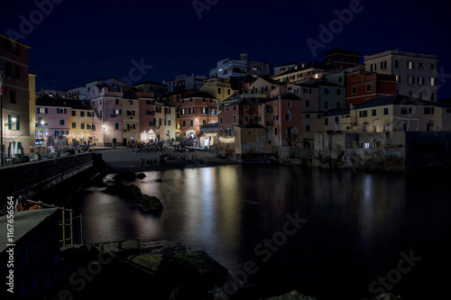 A beautiful coastal village comes alive at night, with serene reflections shimmering on the water photo