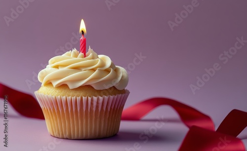 Delicious cupcake with a pink candle and festive ribbons on a purple background