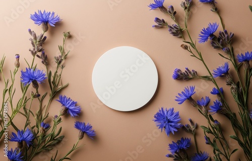 Floral arrangement with blue flowers and a round plate on a soft background