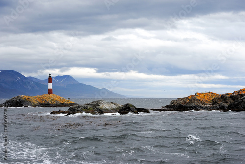 Distant view of Les Eclaireurs lighthouse framed by the Beagle Channel and mountains photo