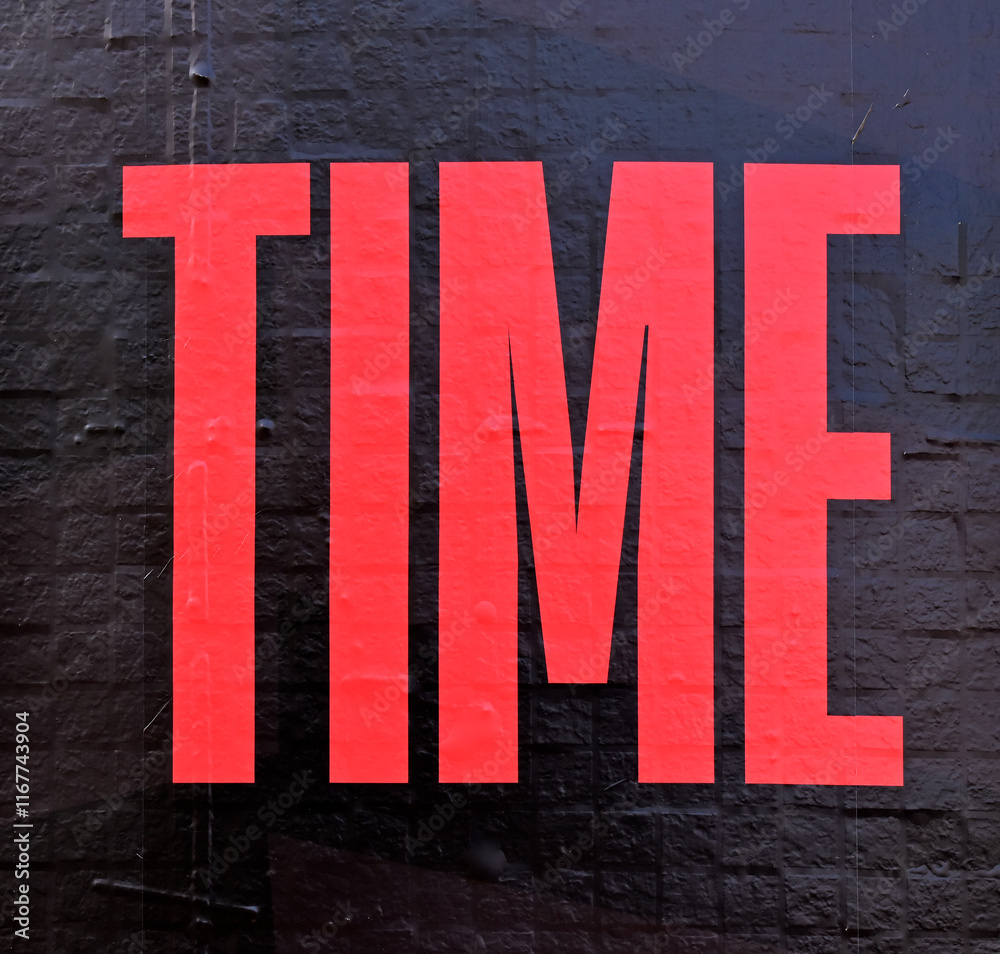Word TIME in red on a black wall
