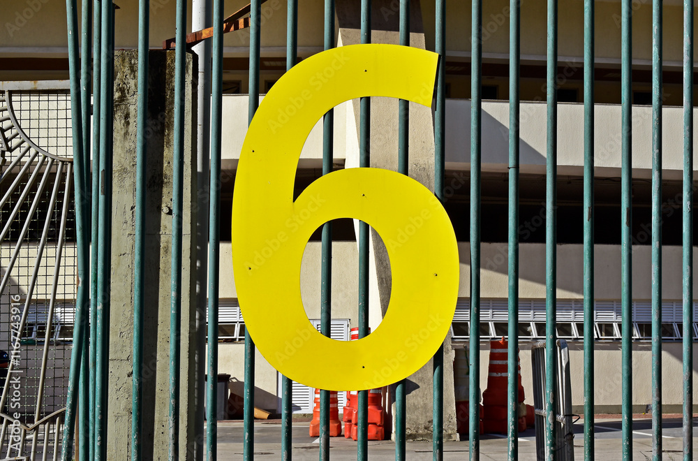 Number six in metal on metallic grid