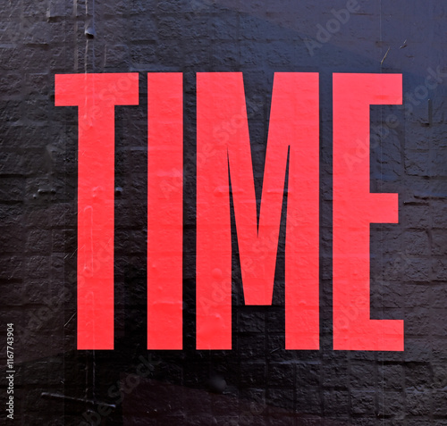Word TIME in red on a black wall