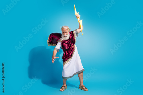 Photo of antique olympian god wearing traditional toga throw lightning bolt isolated on blue color background photo