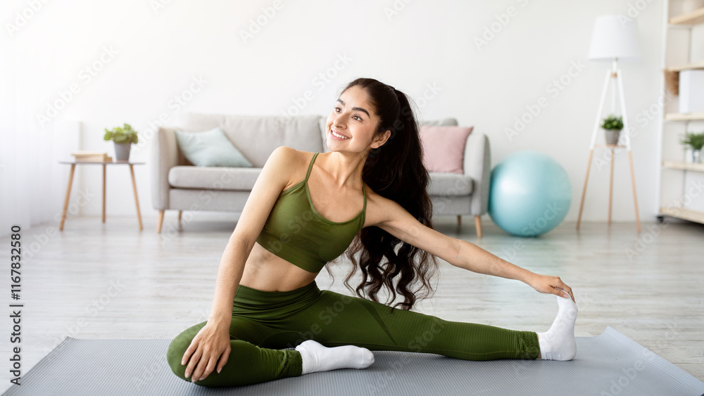 Domestic sports concept. Athletic Indian woman in sportswear doing fitness exercises on yoga mat, stretching her legs at home. Fit young Eastern lady staying flexible during covid lockdown Domestic sports concept. Athletic Indian woman in sportswear doing fitness exercises on yoga mat, stretching her legs at home. Fit young Eastern lady staying flexible during covid lockdown