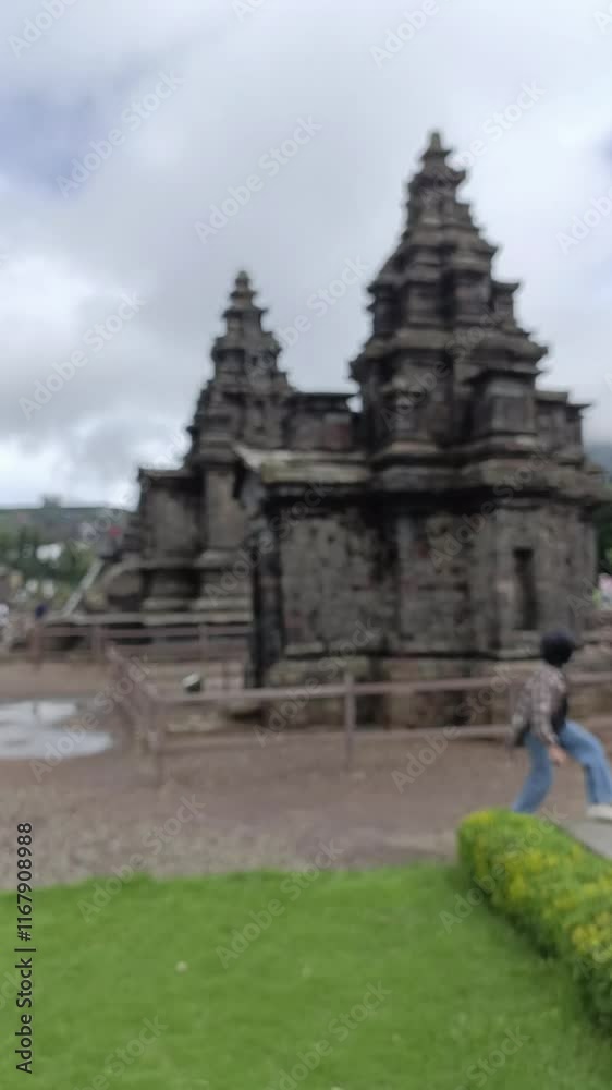 blur of a tourist walking through a temple located between mountains covered in mist from the background concept of temple and hill, out of focus, abstract blur of a tourist walking through a temple located between mountains covered in mist from the background concept of temple and hill, out of focus, abstract