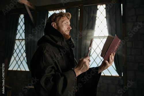 Medieval priest holding cross and holy bible performing exorcism rite photo