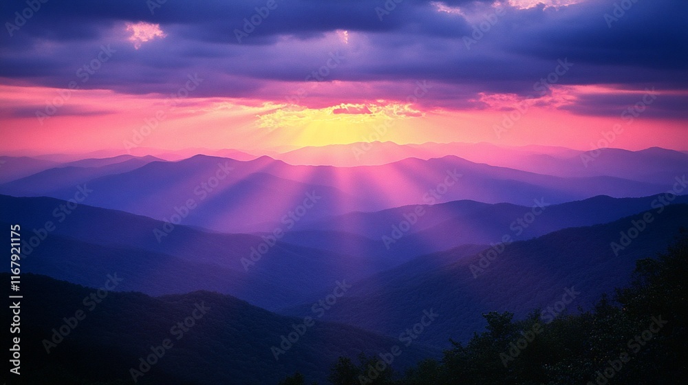 Fototapeta premium Vibrant sunset casting rays over majestic mountain ranges.