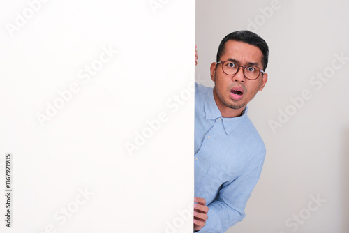 Canvastavla A man peeking behind a wall with shocked face expression