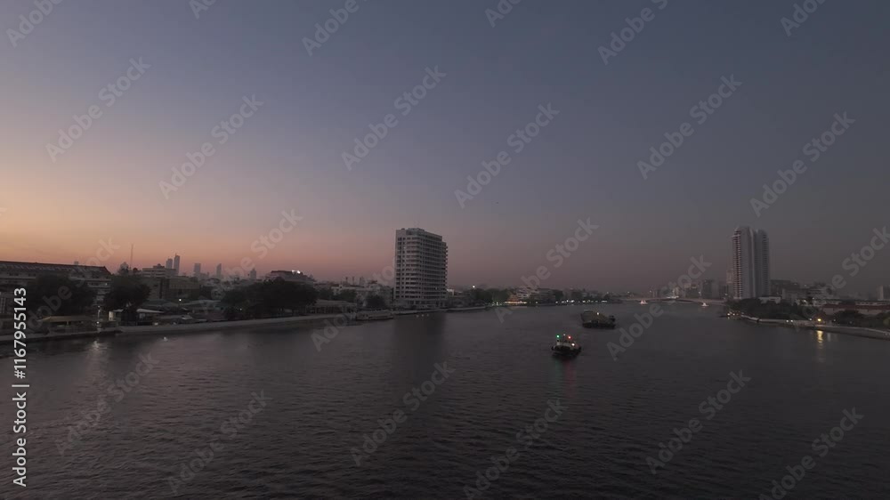 Twilight descends over a tranquil river, reflecting the fading city lights as boats drift through the calm water. Twilight descends over a tranquil river, reflecting the fading city lights as boats drift through the calm water.