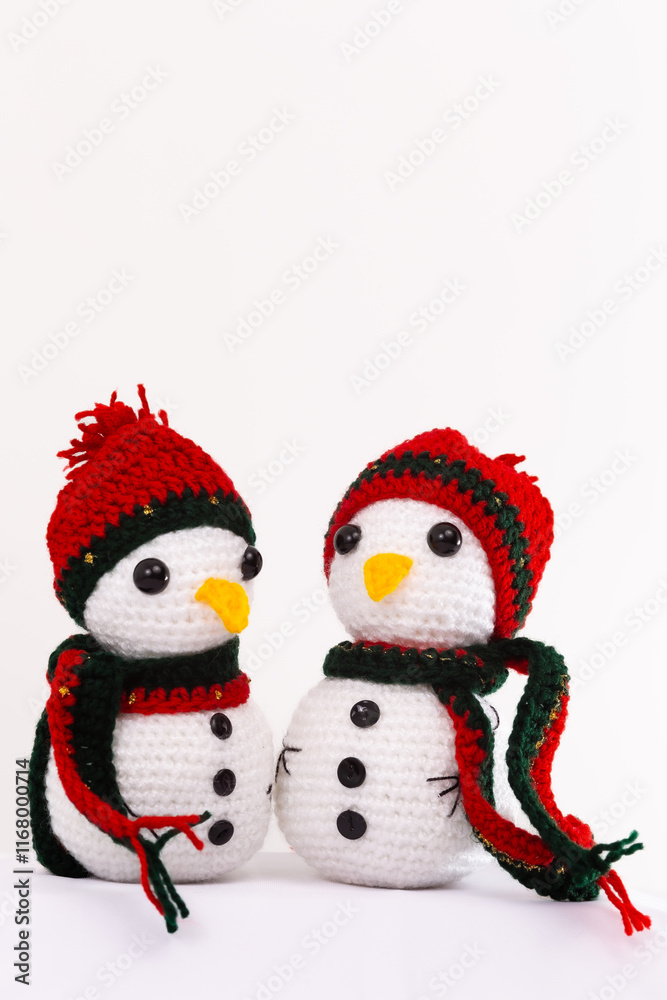 Two snowmen with red hats and scarves are sitting next to each other Two snowmen with red hats and scarves are sitting next to each other