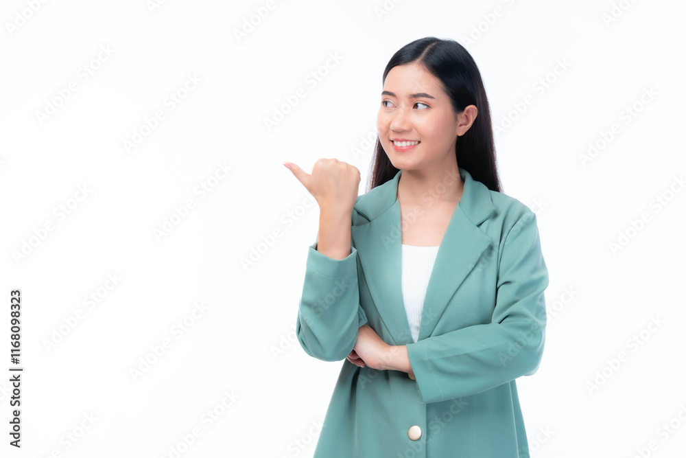 Beautiful young woman in stylish green blazer smiling , pointing thumb backward, presenting or promoting something, standing isolated on a clean white background for advertising and business concept Beautiful young woman in stylish green blazer smiling , pointing thumb backward, presenting or promoting something, standing isolated on a clean white background for advertising and business concept