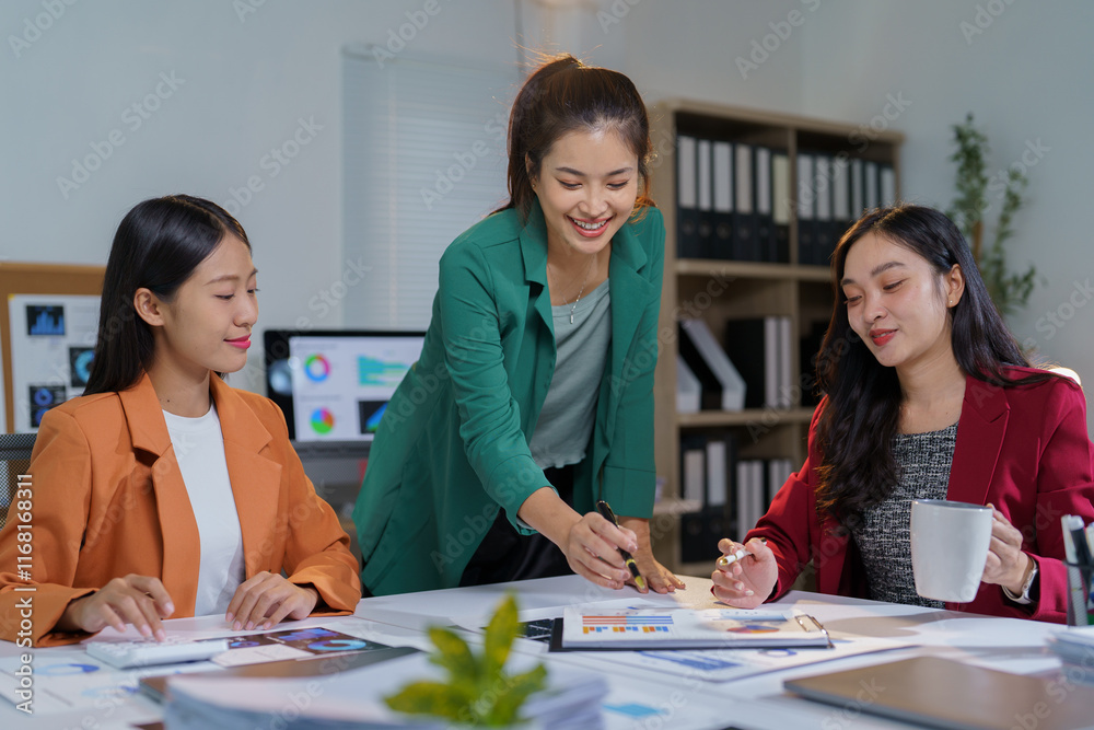 Three asian businesswomen are discussing financial charts and analyzing statistical graphs while working together in modern office, showing teamwork and cooperation Three asian businesswomen are discussing financial charts and analyzing statistical graphs while working together in modern office, showing teamwork and cooperation