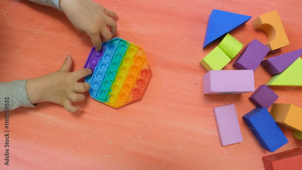 Child playing with silicone toy antistress. Trendy antistress sensory toy fidget push. Alternative therapy. ADHD