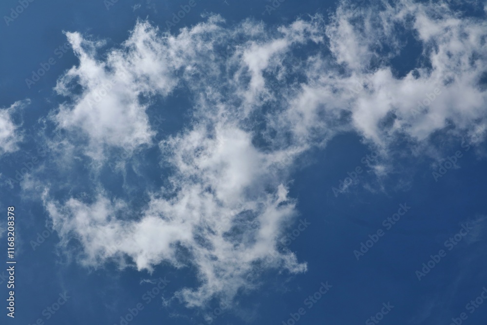 Obraz premium Clear Blue Sky with White Cloud Formations on a Sunny Day
