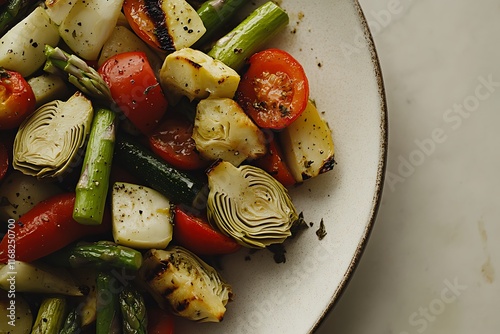 A close-up of a grilled vegetable plate featuring seasonal vegetables like asparagus, artichokes, and zucchini, isolated on a soft beige background, leaving room for text. photo