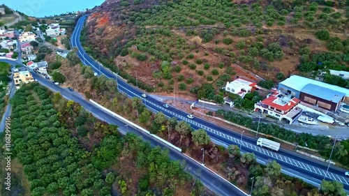 Aerial view over the streets, highways of Kalami, traffic at daylight, grassland and some buildings around, Greece, island photo