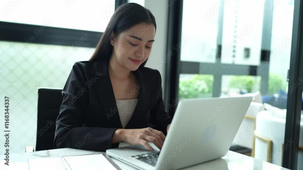 Asian businesswoman using laptop in office