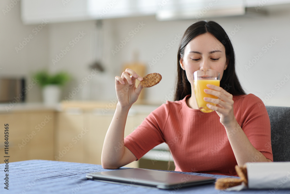 Asian woman eating and drinking orange juice at breakfast Asian woman eating and drinking orange juice at breakfast