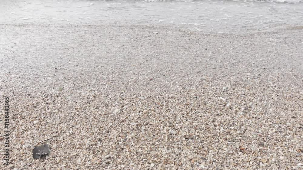 Shallow water on ocean beach. White sand and transparent sea or ocean water with small lazy waves. Ocean waves on the beach sand Shallow water on ocean beach. White sand and transparent sea or ocean water with small lazy waves. Ocean waves on the beach sand