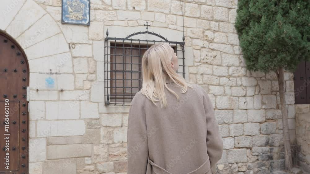 Young student Caucasian woman exploring and observing old stone European tourist buildings with amazement
