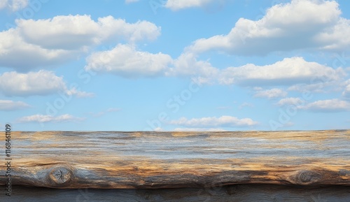 Rustic wooden table against a bright blue sky with fluffy clouds. (1)