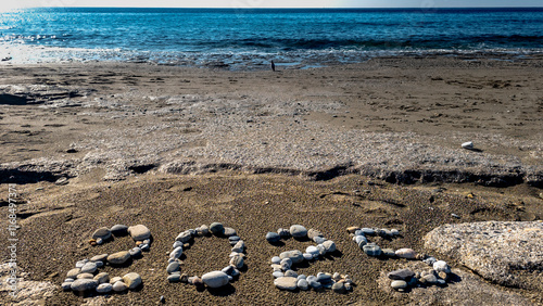 Obraz na płótnie 2025 Written with Stones on Sandy Beach by the Sea w salonie