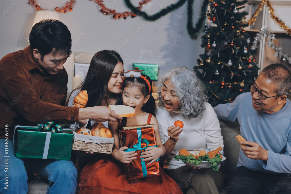 Fototapeta premium Portrait of Asian family exchanging presents during christmas at home. Attractive happy people holding gift box, celebrate holiday thanksgiving, xmas eve tradition in living room in house together.