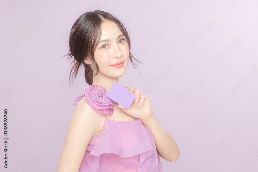 Young Asian beauty woman model pull back hair with natural makeup look on face and perfect clean skin hold card on violet background. Facial treatment, Cosmetology, Spa, Aesthetic, plastic surgery. Young Asian beauty woman model pull back hair with natural makeup look on face and perfect clean skin hold card on violet background. Facial treatment, Cosmetology, Spa, Aesthetic, plastic surgery.