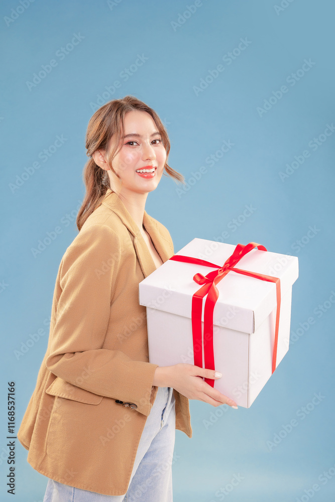 Young attractive elegance Asian woman hand showing mock up gift box with happy relax carefree face expression portrait look at camera on blue background instudio. Young attractive elegance Asian woman hand showing mock up gift box with happy relax carefree face expression portrait look at camera on blue background instudio.