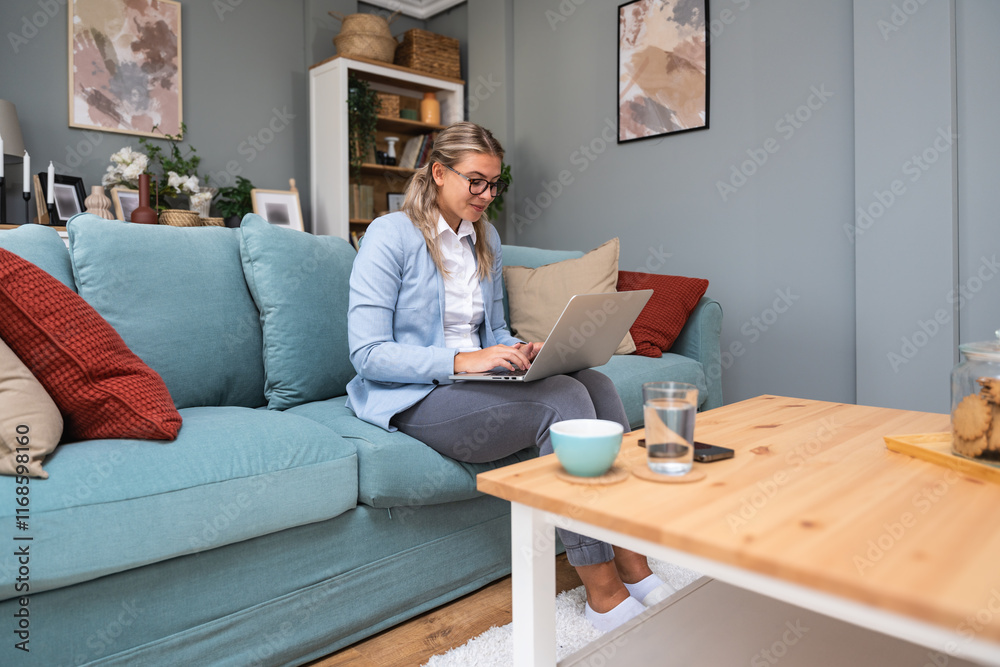 Young confident business woman working at home office on laptop computer, with formal wear and pajamas, video call and work on new project. Comfortable design professional occupation female concept