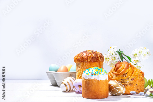 Easter baking background with traditional holiday cakes - kraffin, panettone, paska kulich, with Easter eggs, spring flowers on white wooden table, spring holiday Easter greeting card background photo