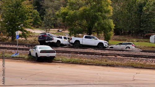 Cinematic footage of vehicle pile-up on railroad tracks. Train carnage.