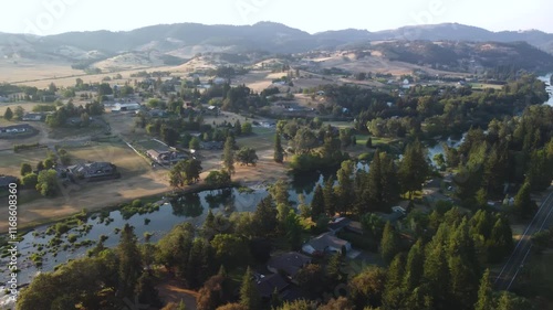 Lush Oregon River Valley at Sunset. North Umpqua River, Roseburg OR, Looking North Towards Amacher. Summer Low Water Line Showing Green Islands and Vibrant Forests. Slow Calm Reflective Water photo