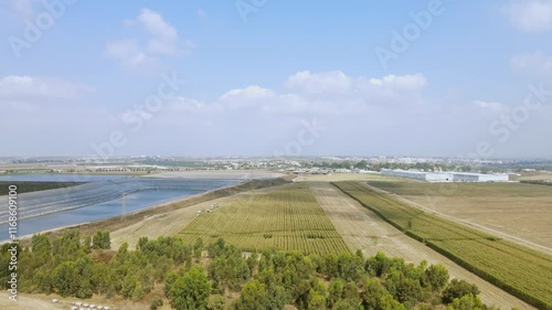 Drone shot of agricultural landscape
A corn field in the middle of harvest, a water reservoir for irrigation.
Blue sky with clouds.
Agricultural settlements in the Judean Lowlands, Israel
