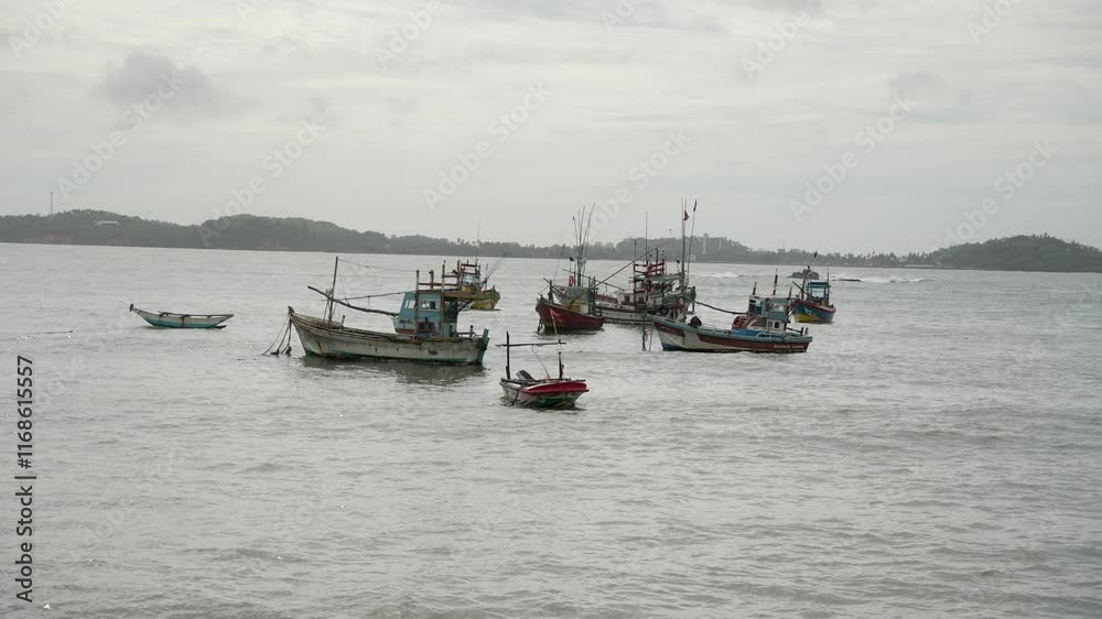 Colorful fishing trawlers floating peacefully in weligama bay, sri lanka, under a cloudy sky, creating a serene maritime scene Colorful fishing trawlers floating peacefully in weligama bay, sri lanka, under a cloudy sky, creating a serene maritime scene