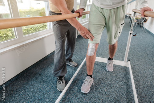 Obraz na plátne young man learning to walk again in rehabilitation on the bars