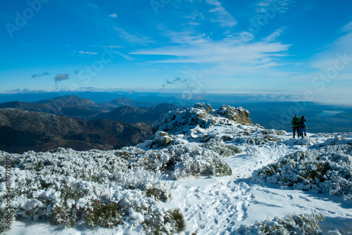 Snowy landscape in the Guadarrama mountain range. Two hikers in the distance