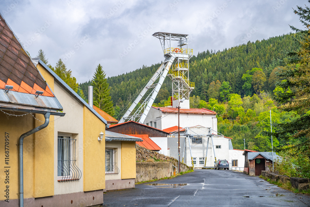 The historic mining tower in Jachymov, Czechia, stands against a backdrop of lush hills. This site represents the region's rich mining history and industrial significance. The historic mining tower in Jachymov, Czechia, stands against a backdrop of lush hills. This site represents the region's rich mining history and industrial significance.
