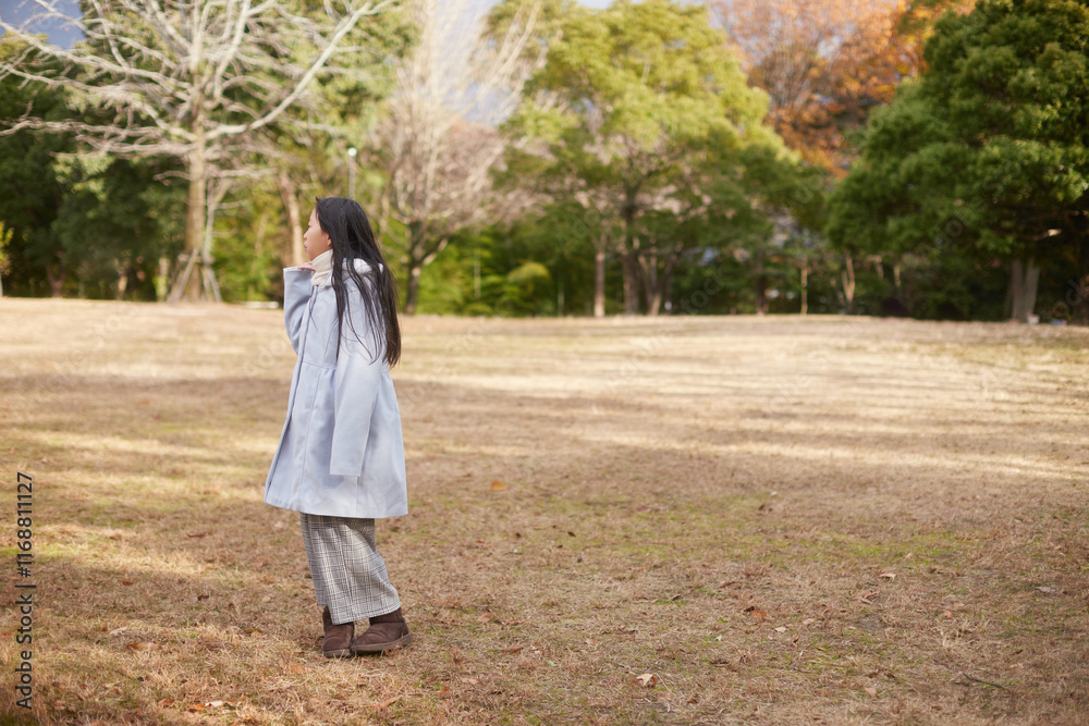 冬の朝の公園で元気で楽しく遊んでいる小学生の女の子の様子