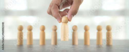 Hand choose wooden person for HR human resources or personal leader training skill or leadership and challenge business team player and organization management teamwork.