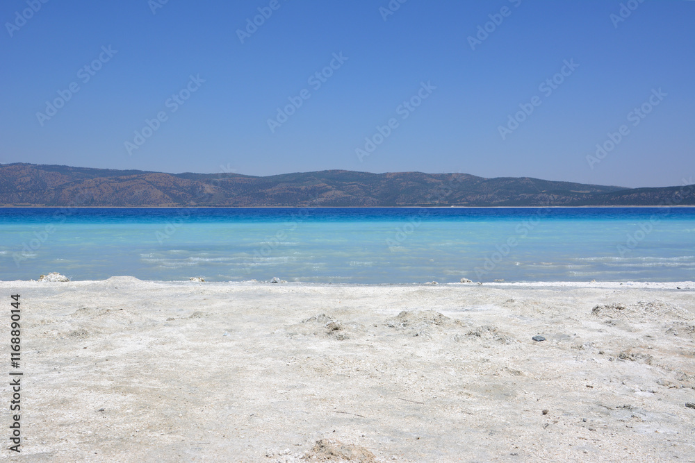 a sandy beach with blue water and no people a sandy beach with blue water and no people