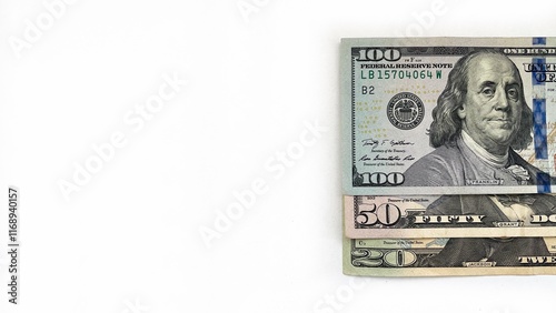 Fotografie Three United States currency notes in denominations of 20 dollar bill, 50 dollar bill, 100 dollar bill, neatly stacked diagonally on a white background