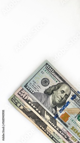Obraz na plátně Three United States currency notes in denominations of 20 dollar bill, 50 dollar bill, 100 dollar bill, neatly stacked diagonally on a white background
