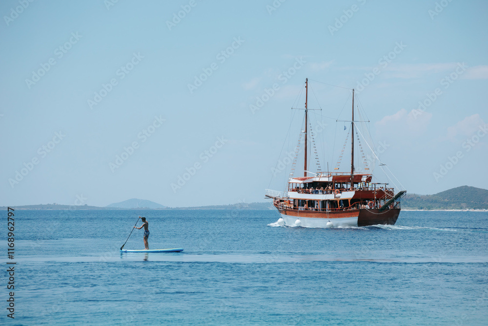 Man is paddling a surfboard on a boat in the ocean Man is paddling a surfboard on a boat in the ocean