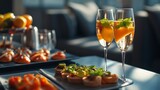 Elegant cocktails with fresh garnishes are paired with gourmet appetizers, creating a stylish dining experience in a sophisticated setting.