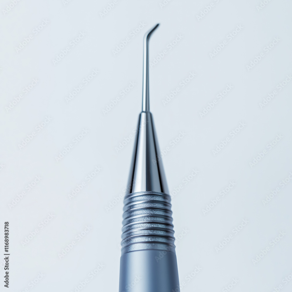 Close-up of the tip of an ultrasonic scaler on a solid light background